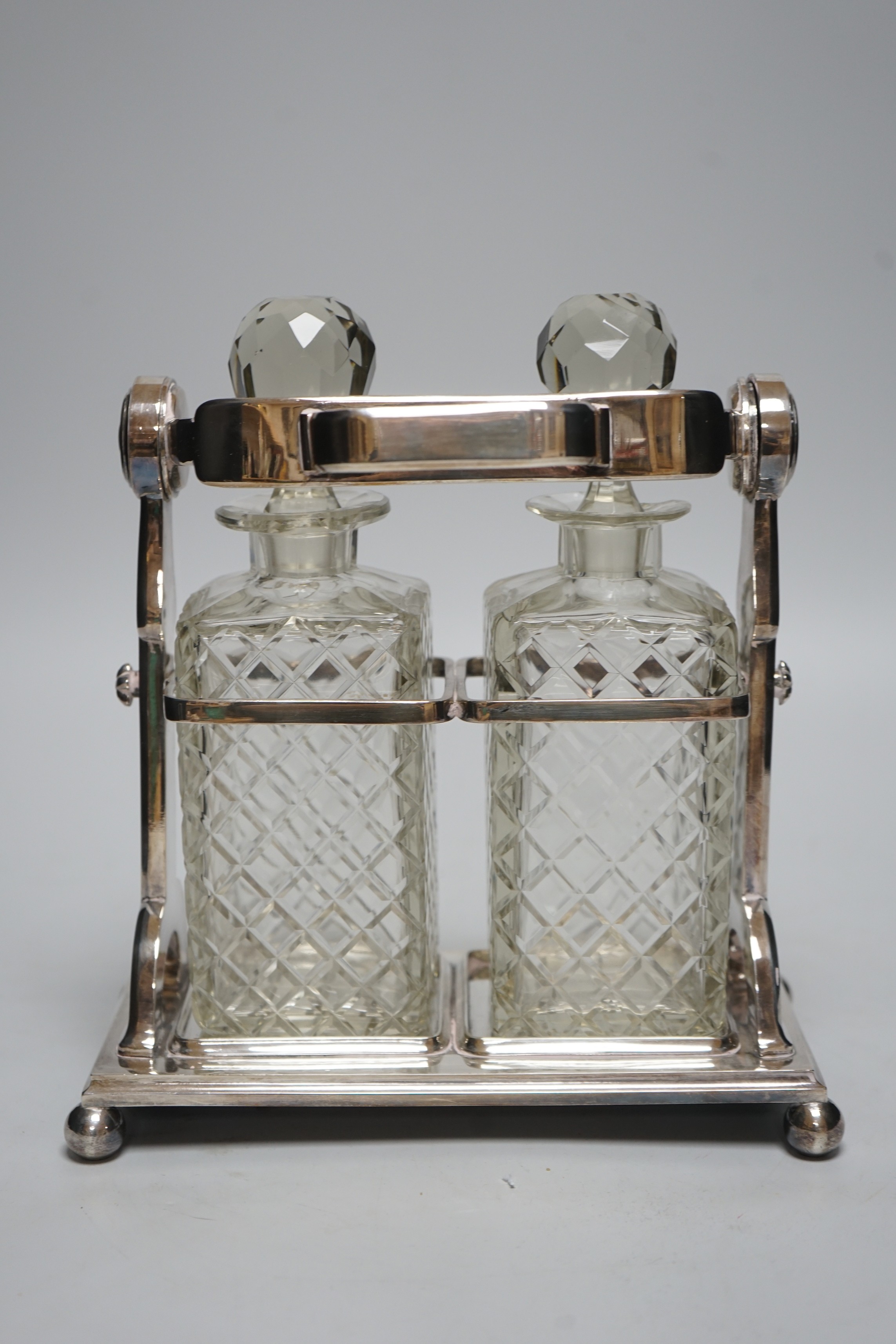 A plated tantalus with two bottles